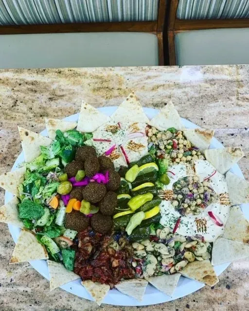 A white plate topped with a variety of food on a table.