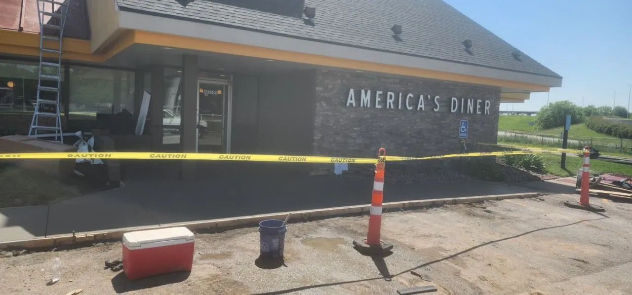 Damaged America’s Diner exterior with caution tape, cones, and debris in front