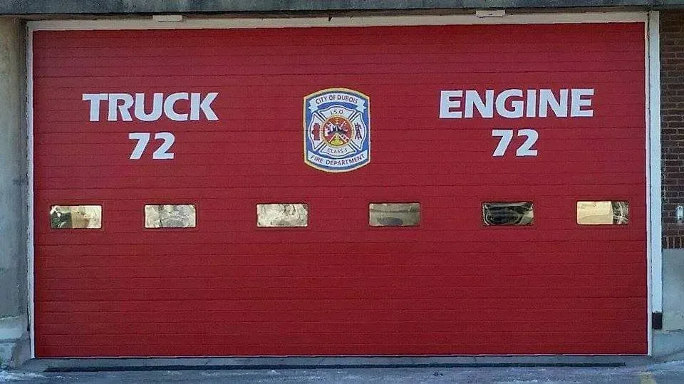 Red fire station garage door labeled “TRUCK 72” and “ENGINE 72” with a fire department emblem.