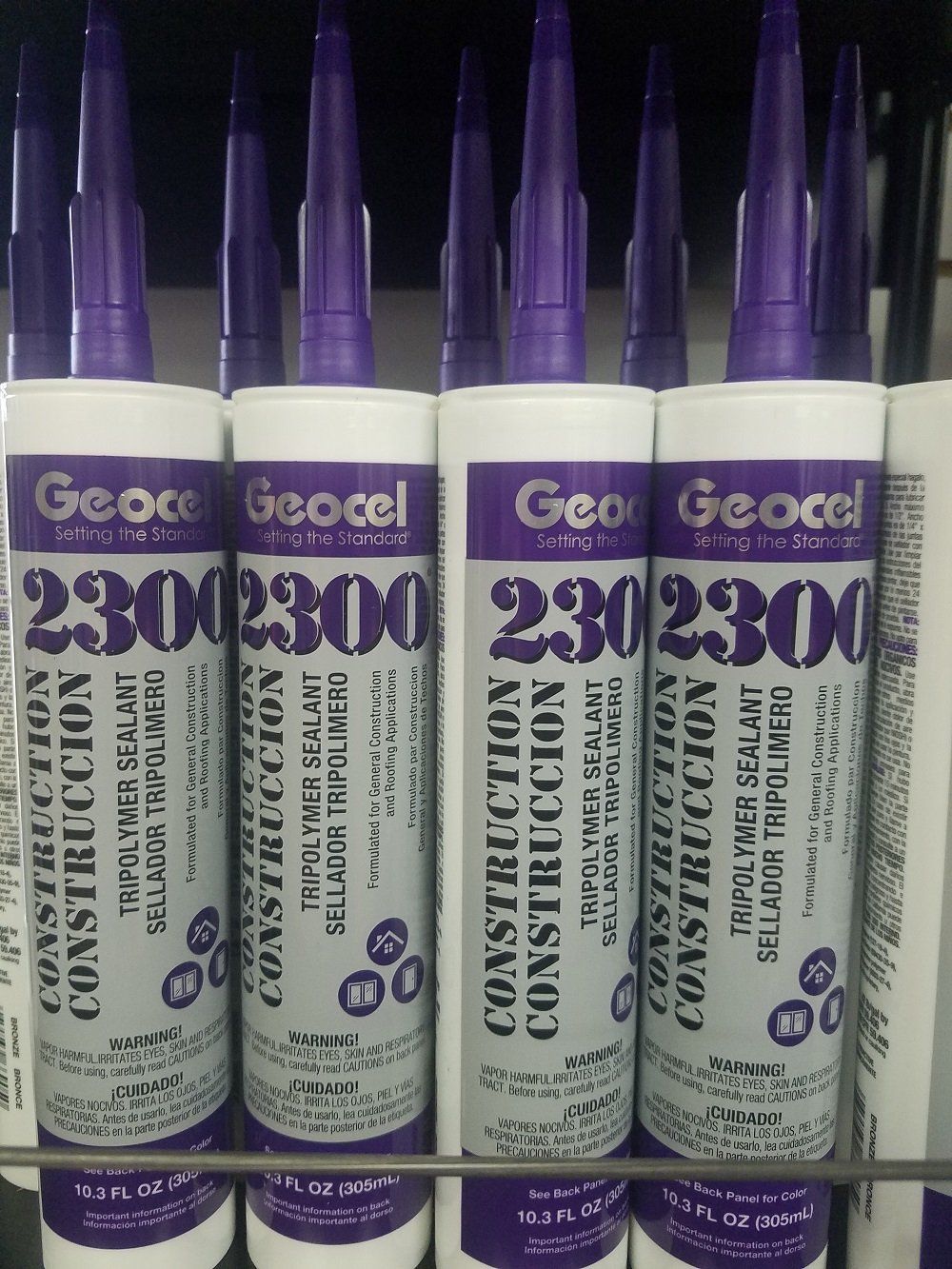 Rows of white and purple Geocel 2300 construction sealant tubes, displayed in a store.