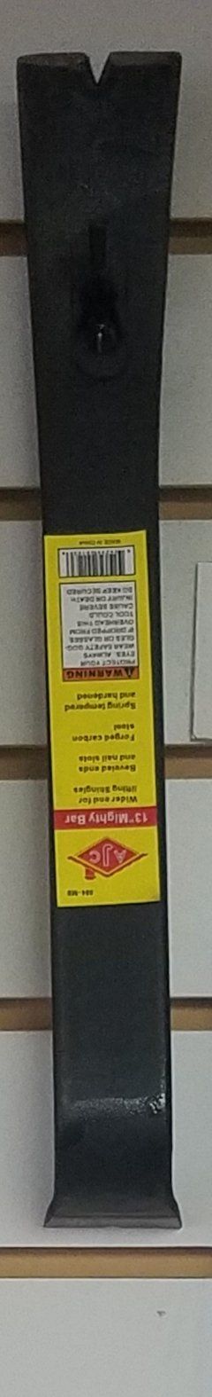 Black pry bar with a yellow label, resting on a shelf. The background is a white and beige wall.