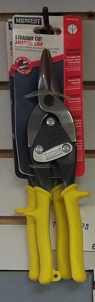 Yellow-handled metal shears on a product package, hanging on a shelf.