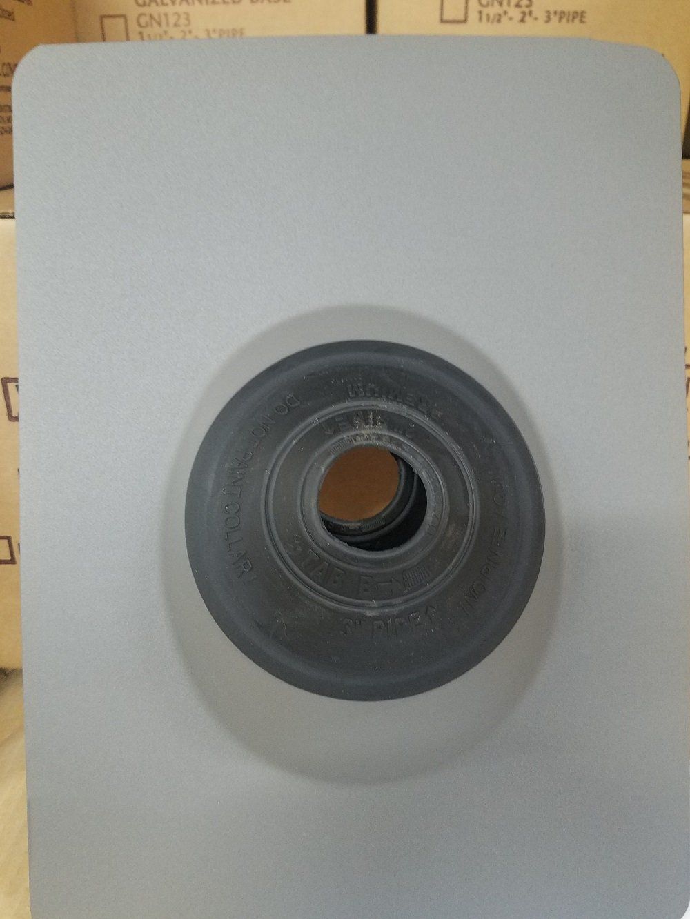 Gray roof flashing with a circular pipe opening.