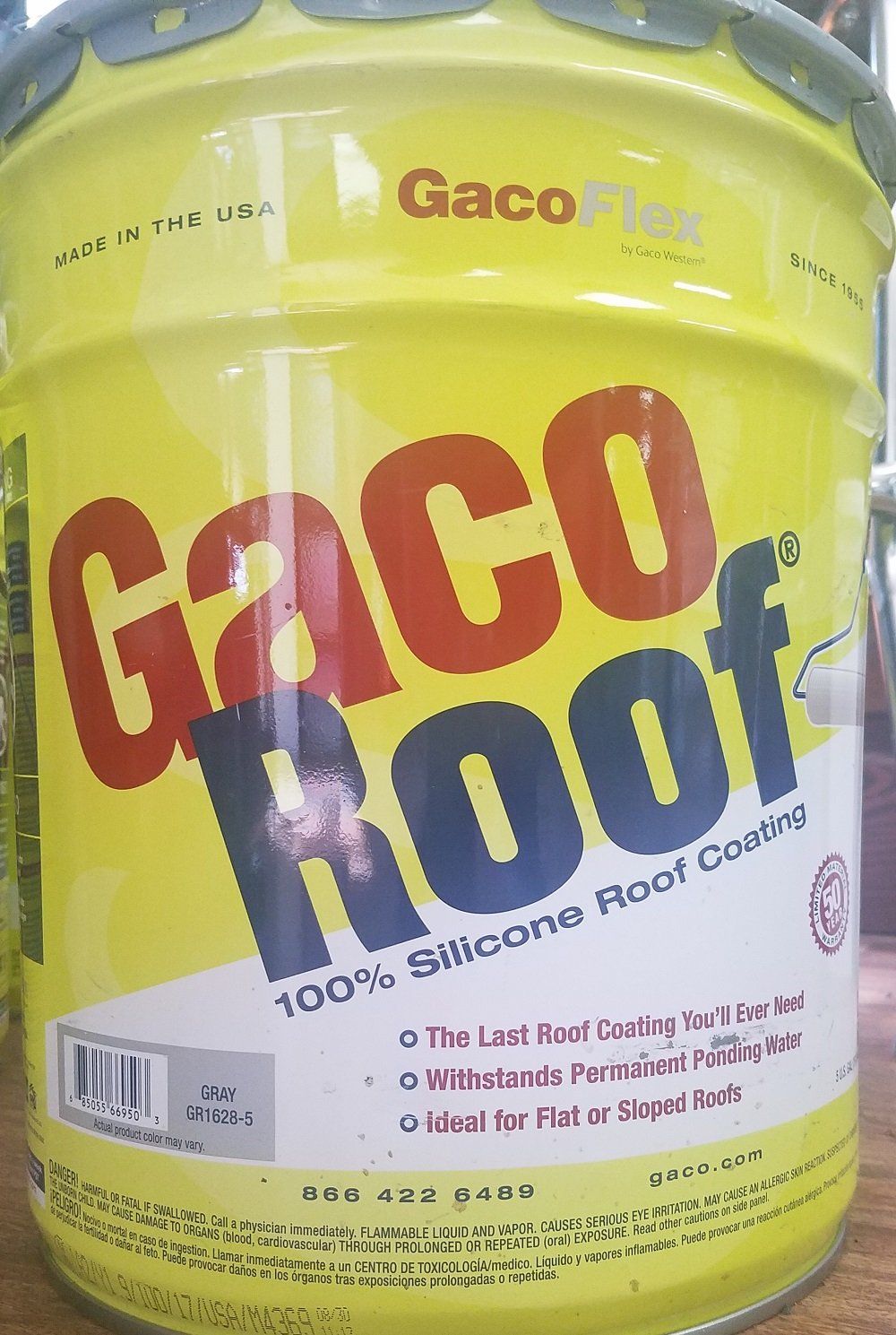 Yellow can of Gaco Roof 100% Silicone Roof Coating with red and blue lettering.