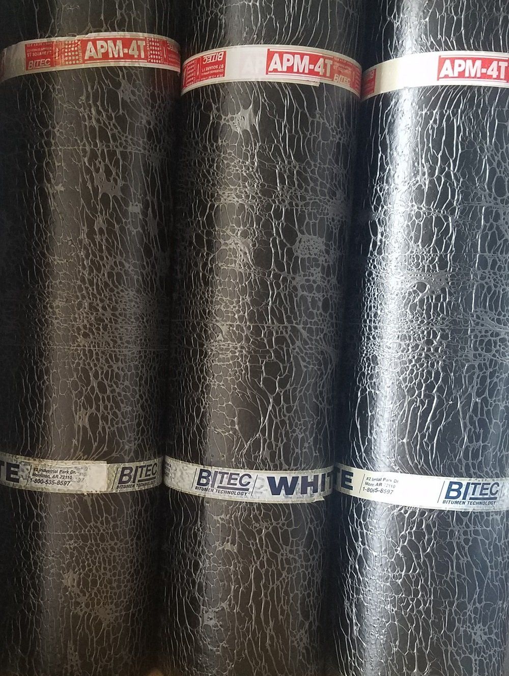 Black roofing rolls stacked vertically with white bands, labeled APM-4T and White.