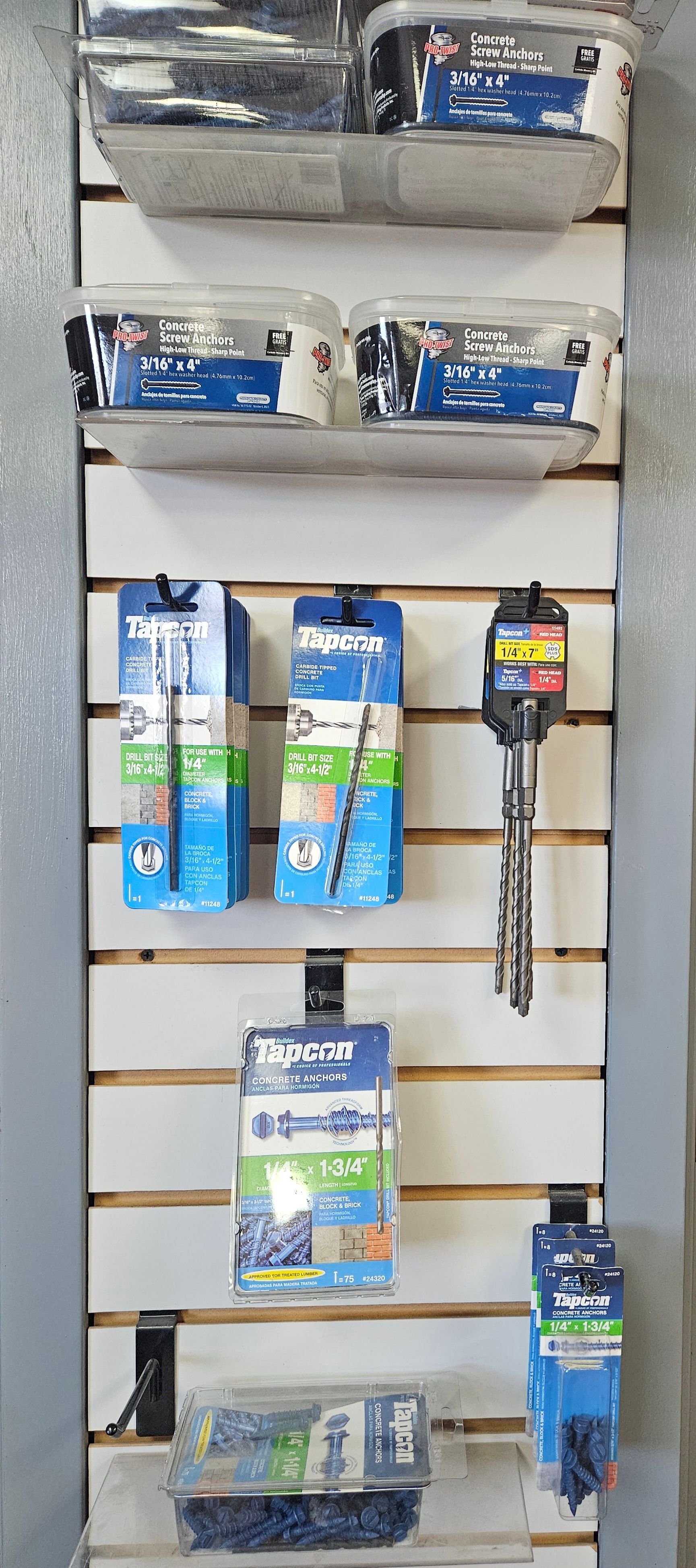 Various blue, white, and clear packaged items displayed on a retail slat wall.