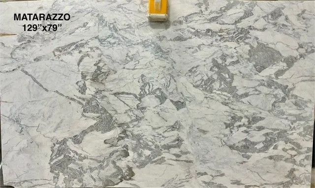 Marble tile sample with gray and white veining, labeled “Matarazzo 129”x79””