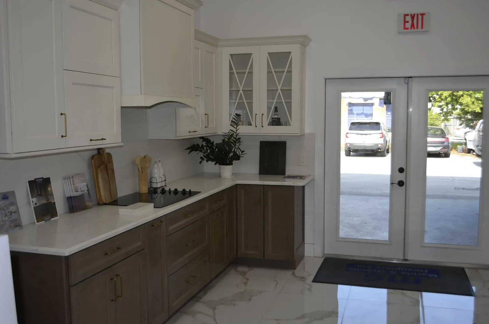 Bright lobby with white cabinets, countertop, glass door, and sunlight on tiled floor