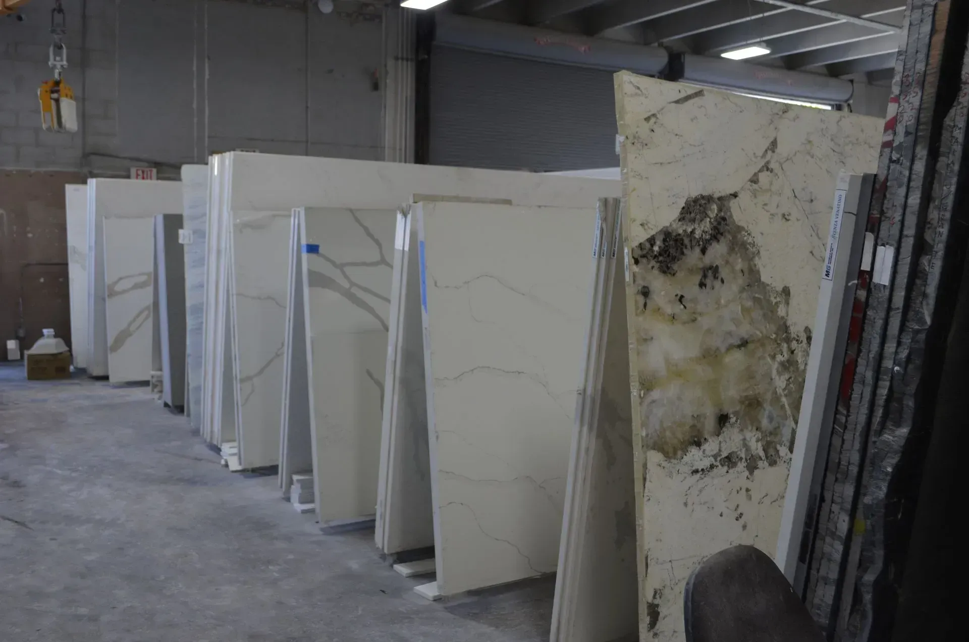 Slabs of marble or stone standing upright in a warehouse, including one stained slab in front
