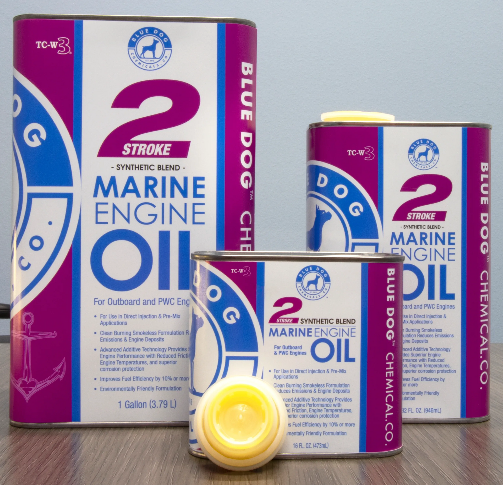 Three cans of blue dog marine engine oil on a table