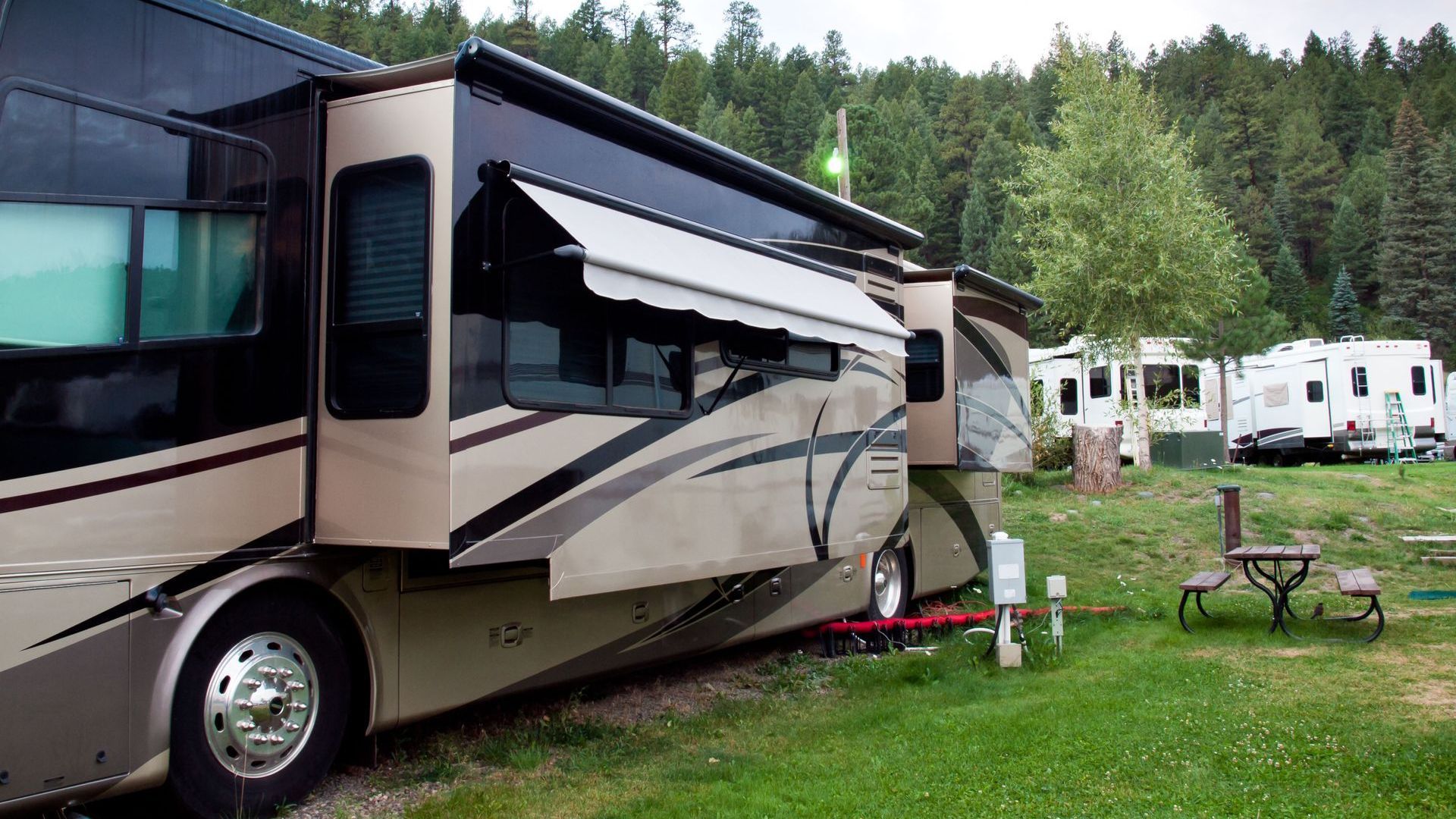 A large rv is parked in a grassy field.