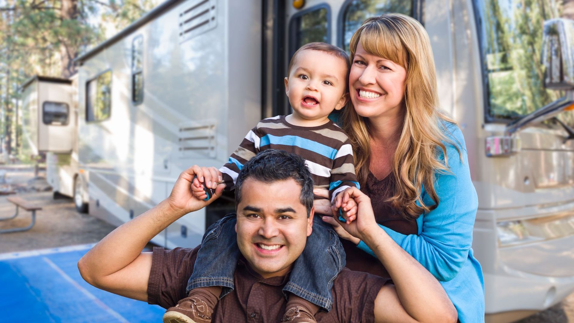 A family is posing for a picture in front of a rv.