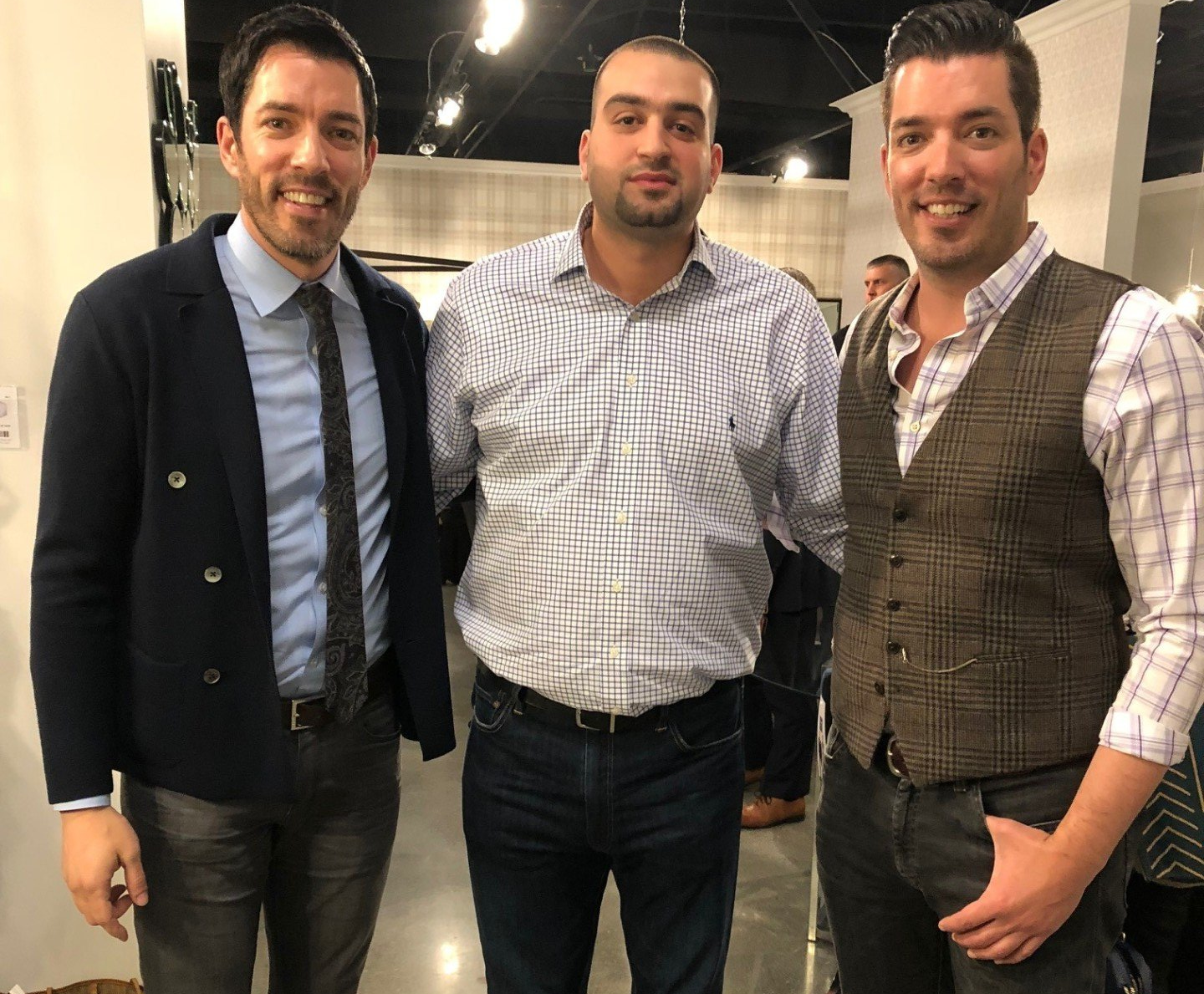 Three men are posing for a picture together in a room.