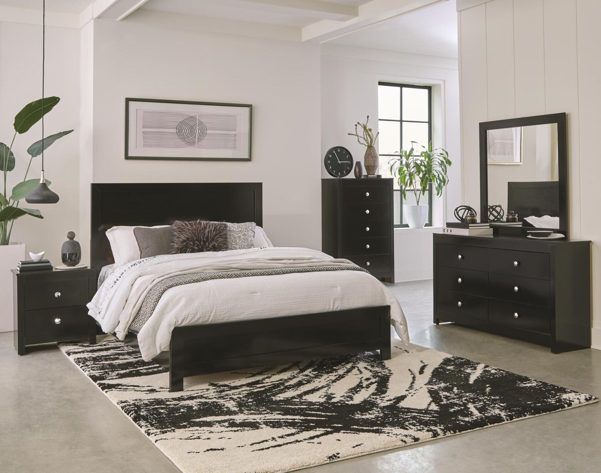 A bedroom with a bed , dresser , nightstand , mirror and rug.