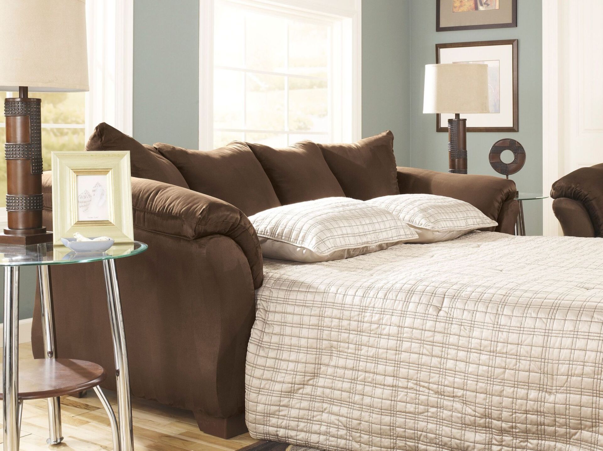 A living room with a couch that has been converted into a bed