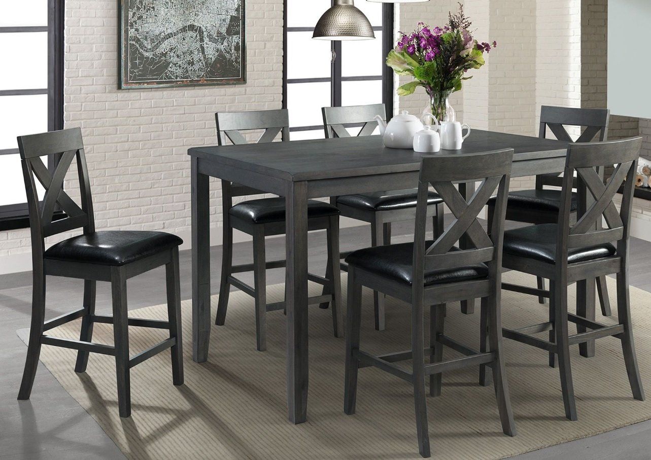 A dining room table and chairs with a vase of flowers on it