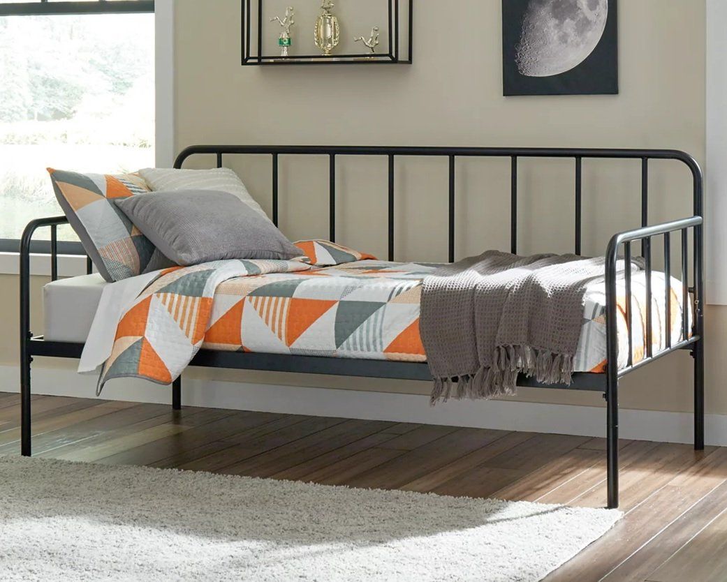 A day bed is sitting in a bedroom next to a window.