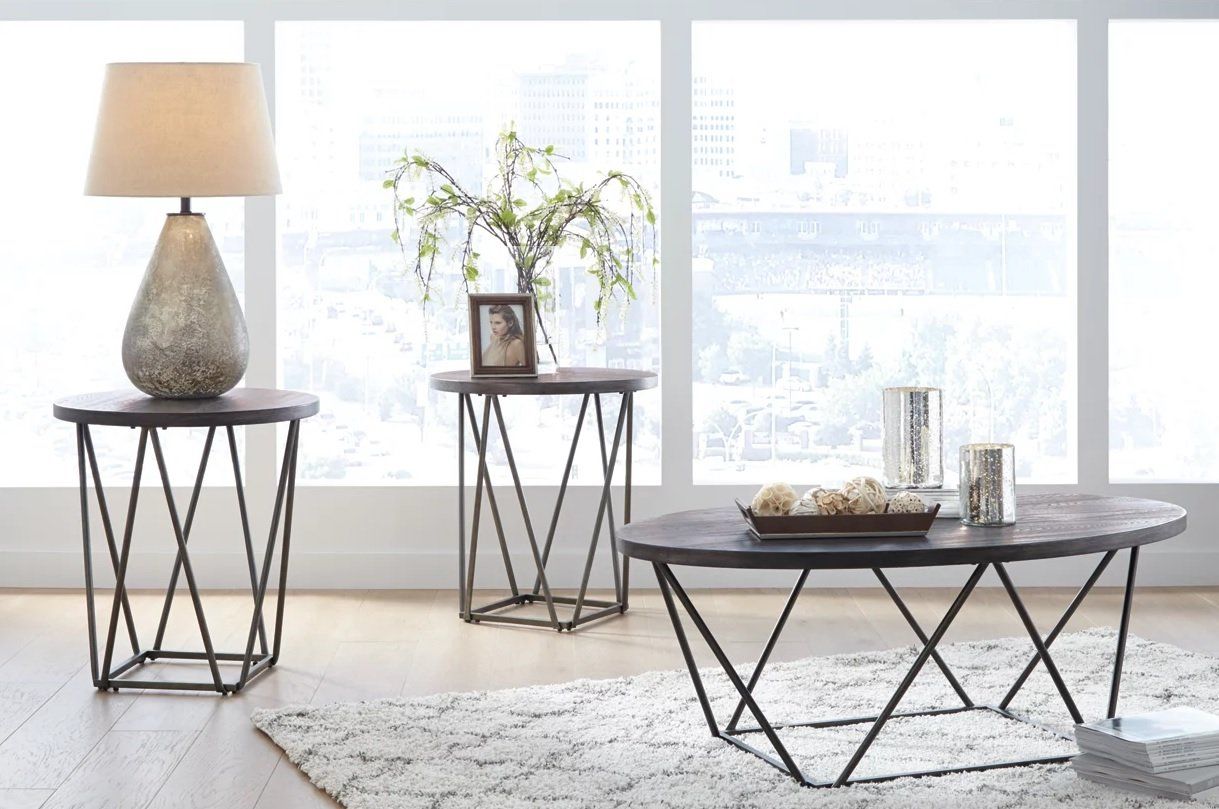 A living room with a coffee table , end tables , and a lamp.