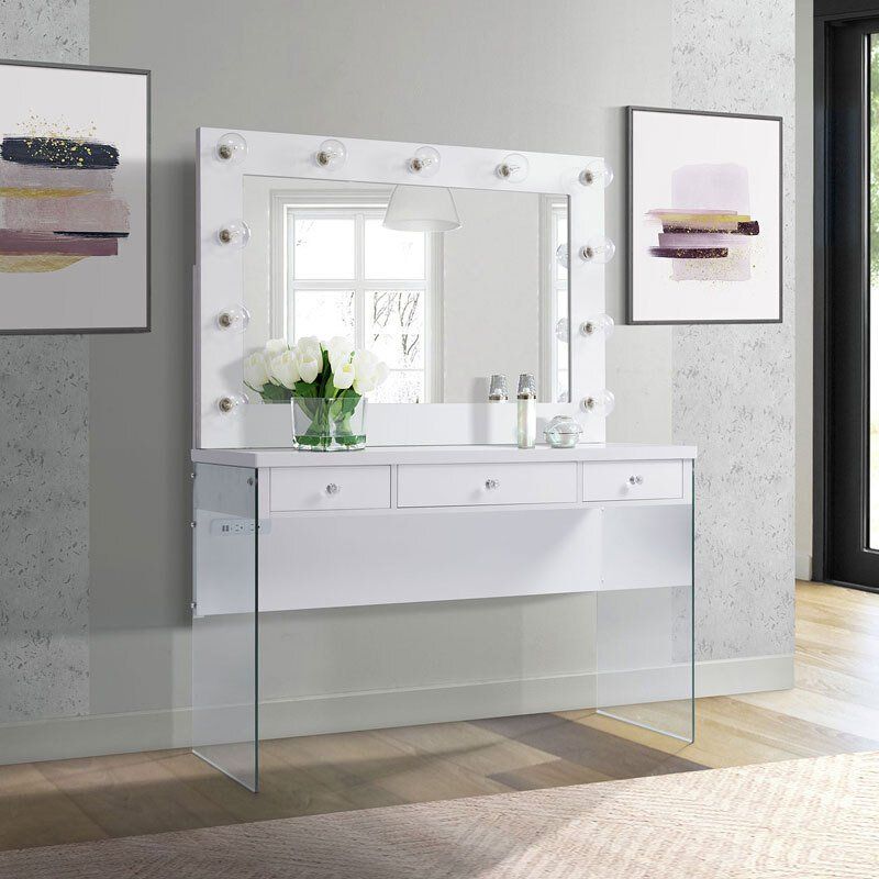 A white vanity with a mirror and drawers in a room.
