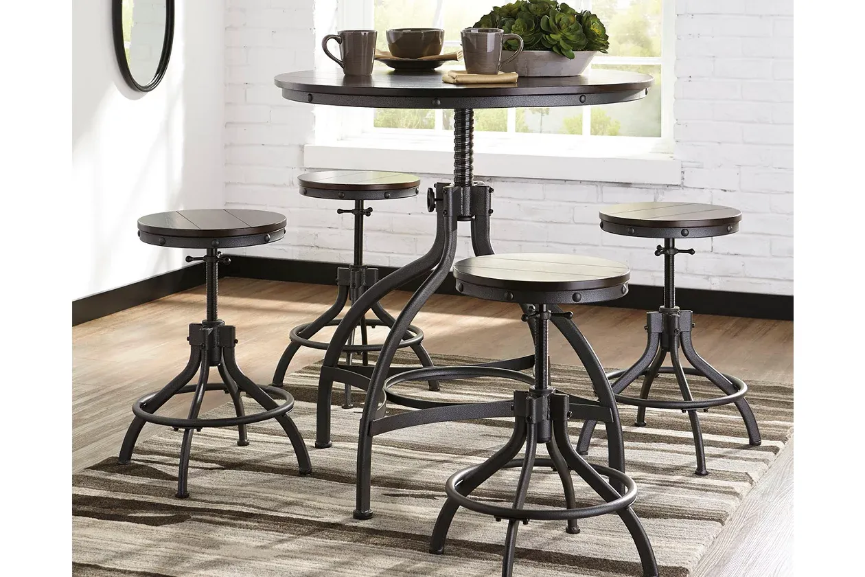 A table and stools are sitting on a rug in a living room.