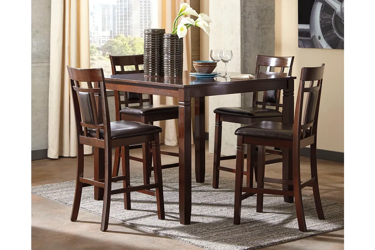 A dining room table with four chairs and a rug