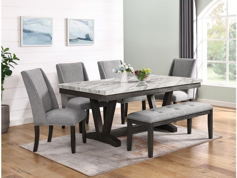 A dining room with a table , chairs , and a bench.