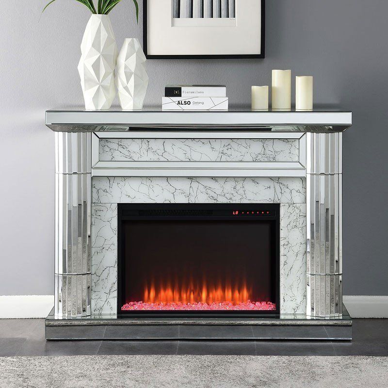 A fireplace with a mirrored mantle and candles on it