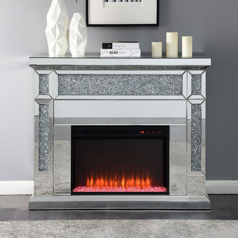 A fireplace with a mirrored mantle and candles on it