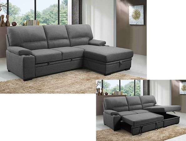 A grey sectional couch is sitting on a rug in a living room.