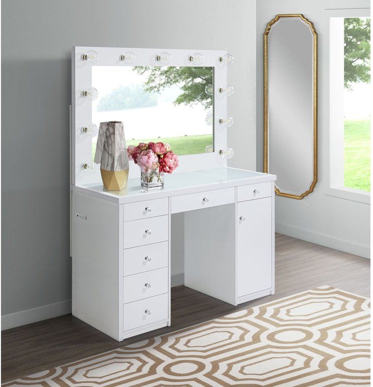 A white vanity with a mirror and lights on it in a room.
