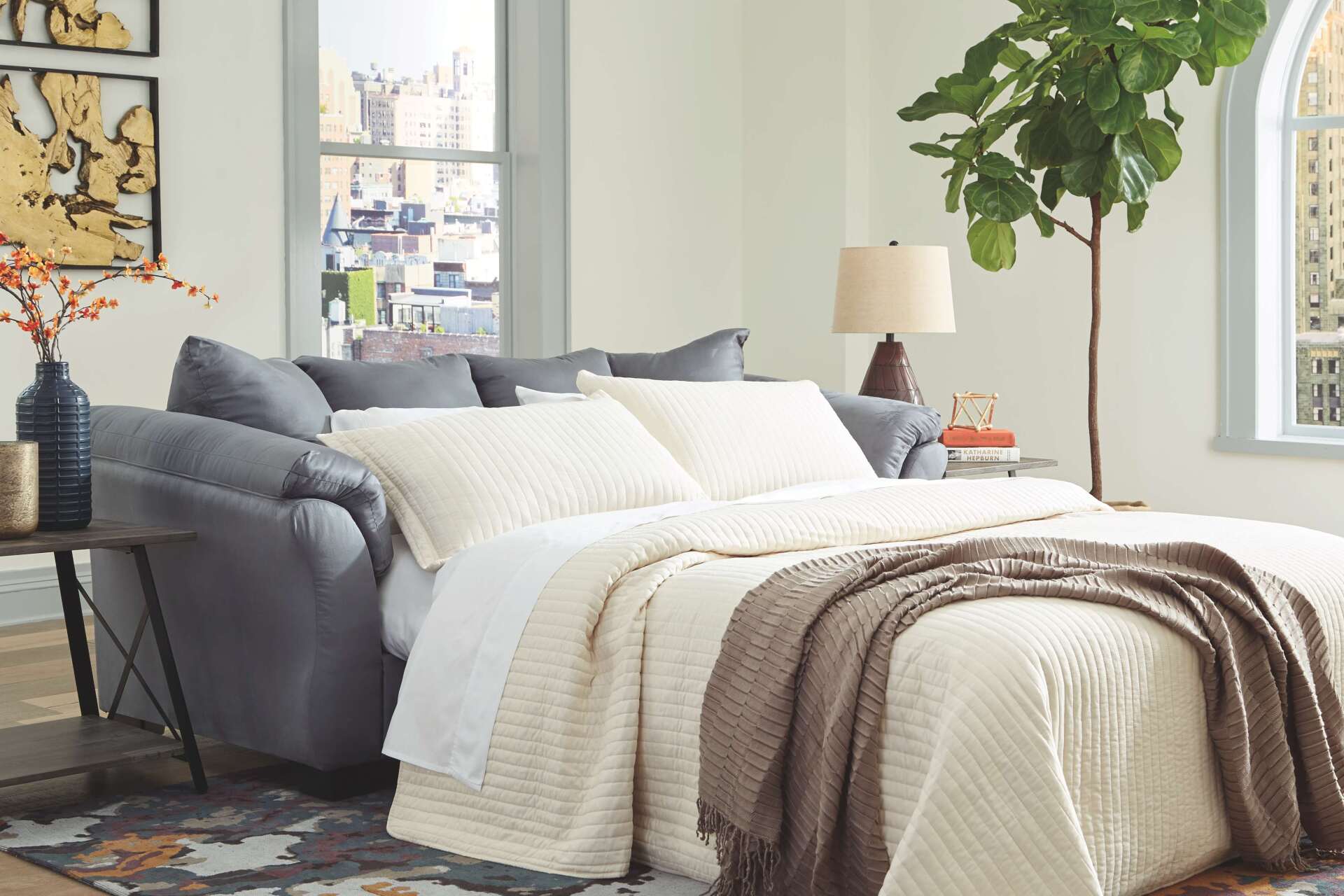 A living room with a couch that turns into a bed.