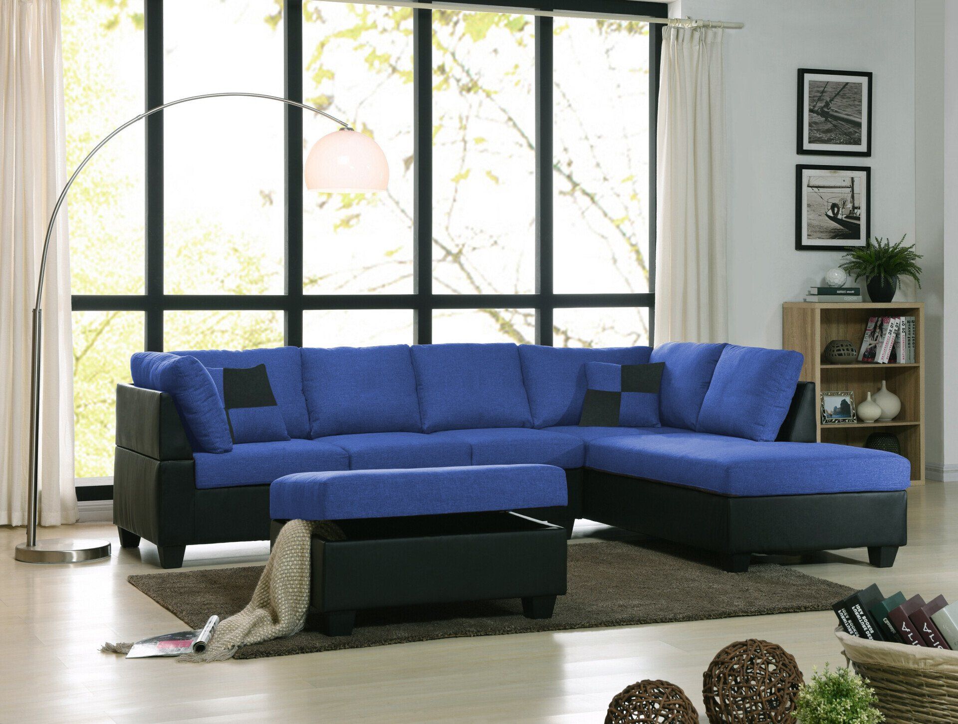 A living room with a blue sectional couch and a black ottoman