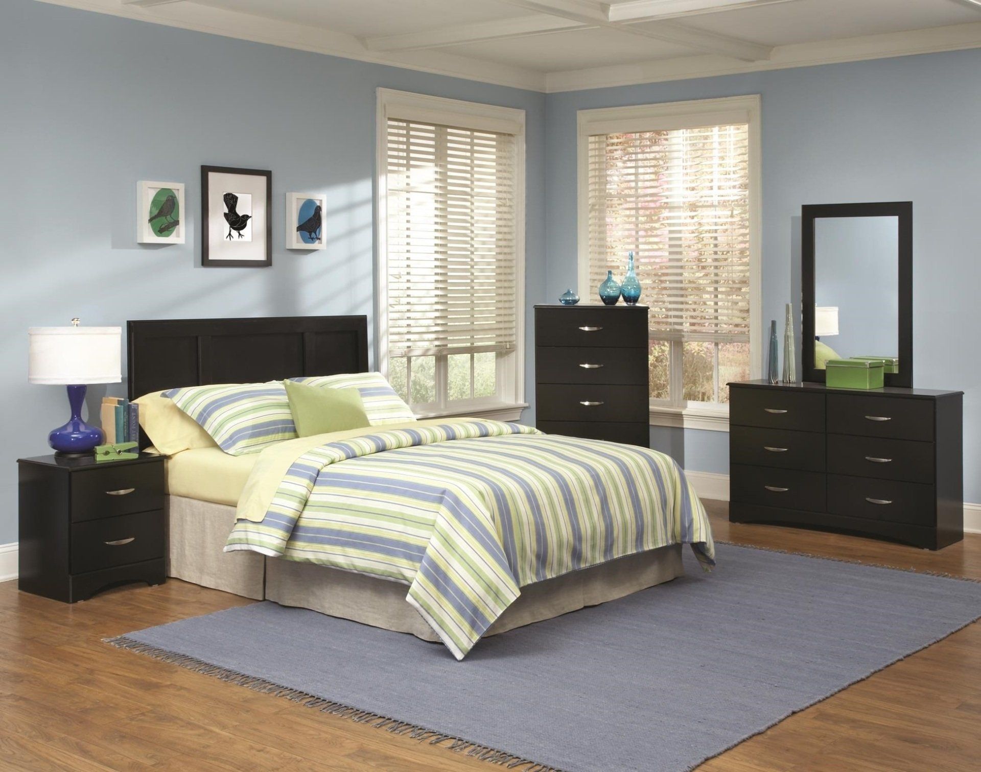 A bedroom with a bed dresser nightstand and mirror