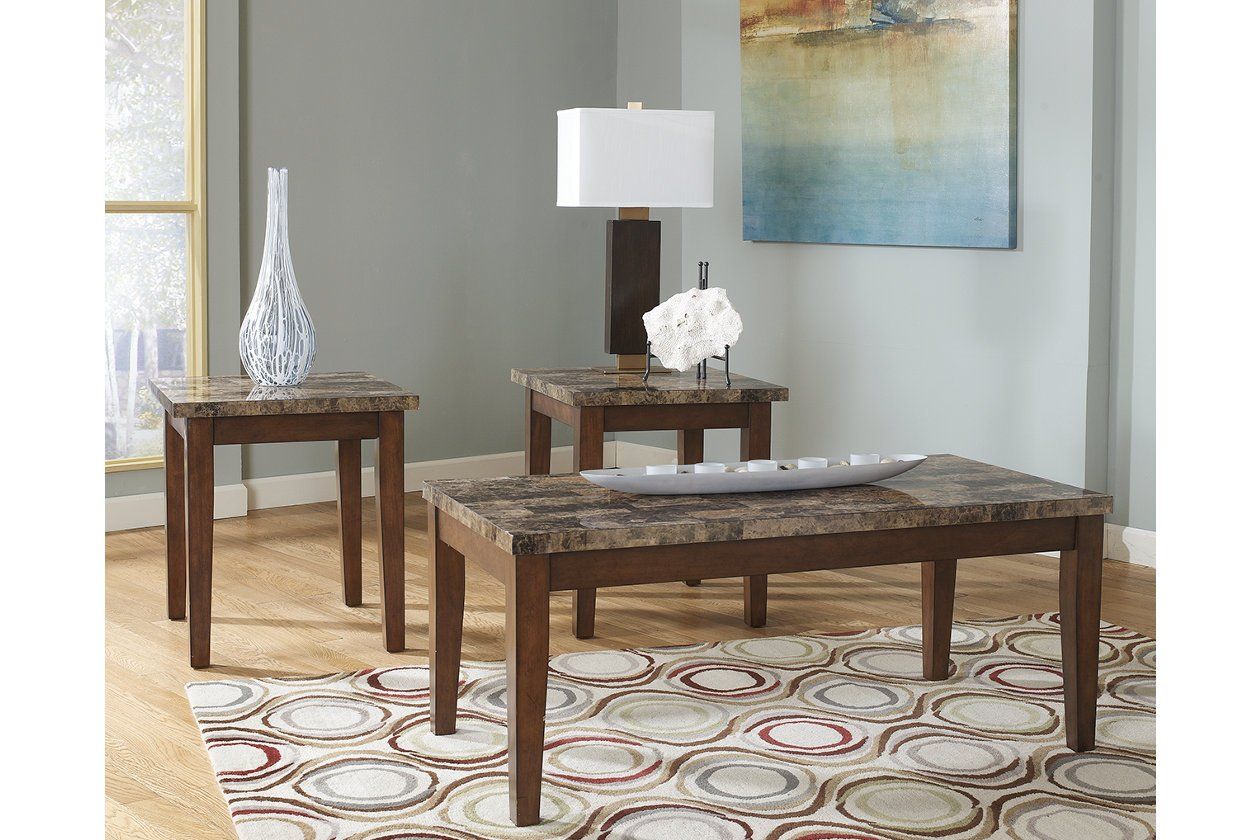 A living room with three coffee tables and a lamp.