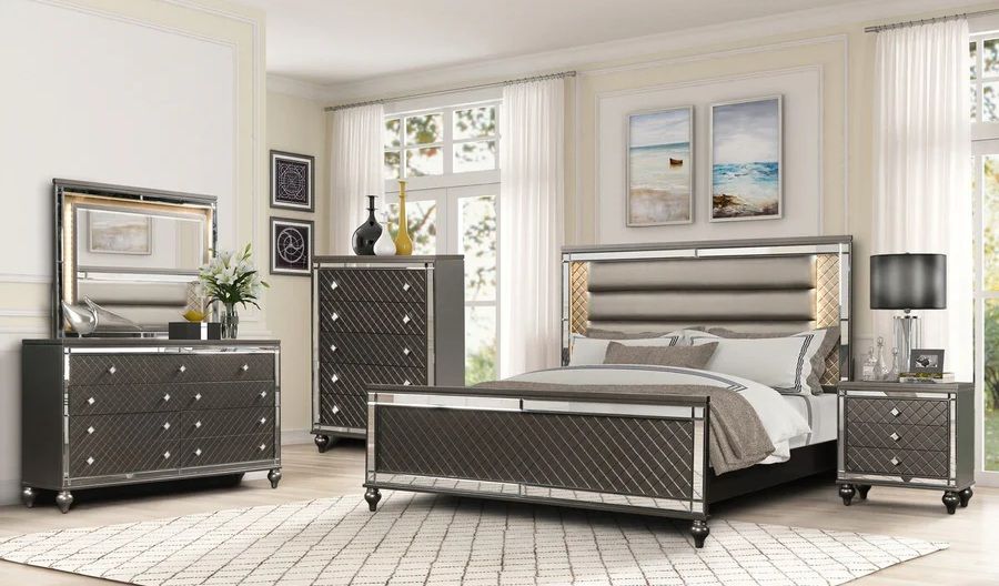 A bedroom with a bed , dresser , nightstand , mirror and rug.