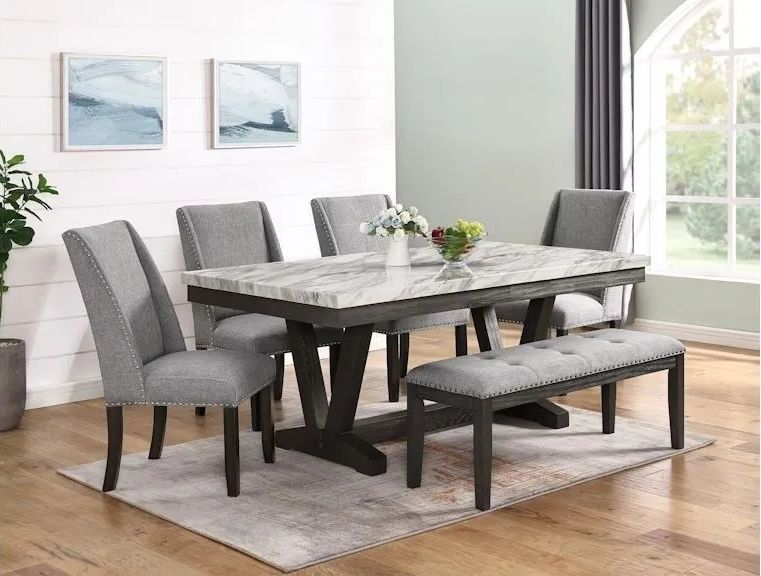 Dining room set with marble top table, gray chairs, and bench.