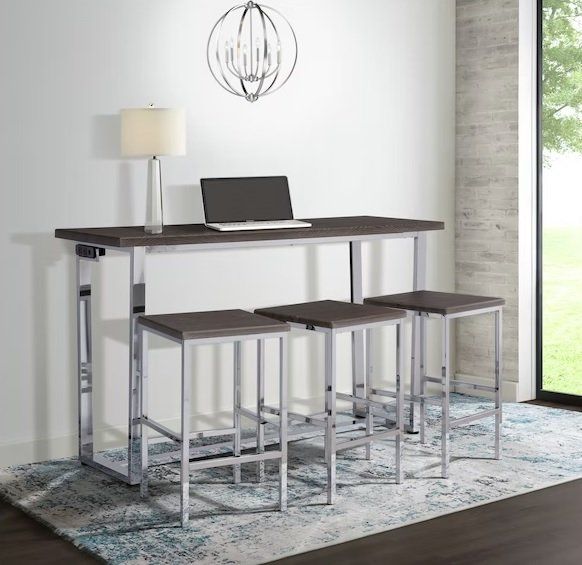 A bar table with stools and a laptop on it in a living room.
