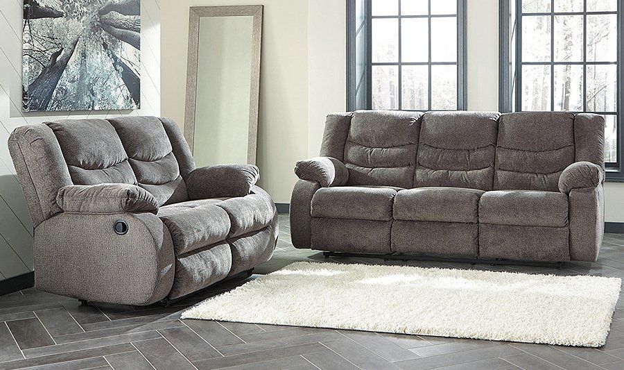 A living room with two reclining couches and a rug.