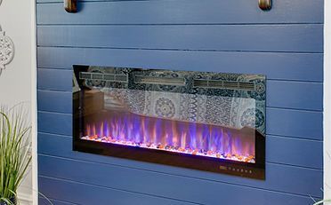 Electric fireplace with blue and purple flames set into a blue shiplap wall.