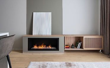 Fireplace with flames, wooden cabinet, artwork, and gray walls in a modern living room.