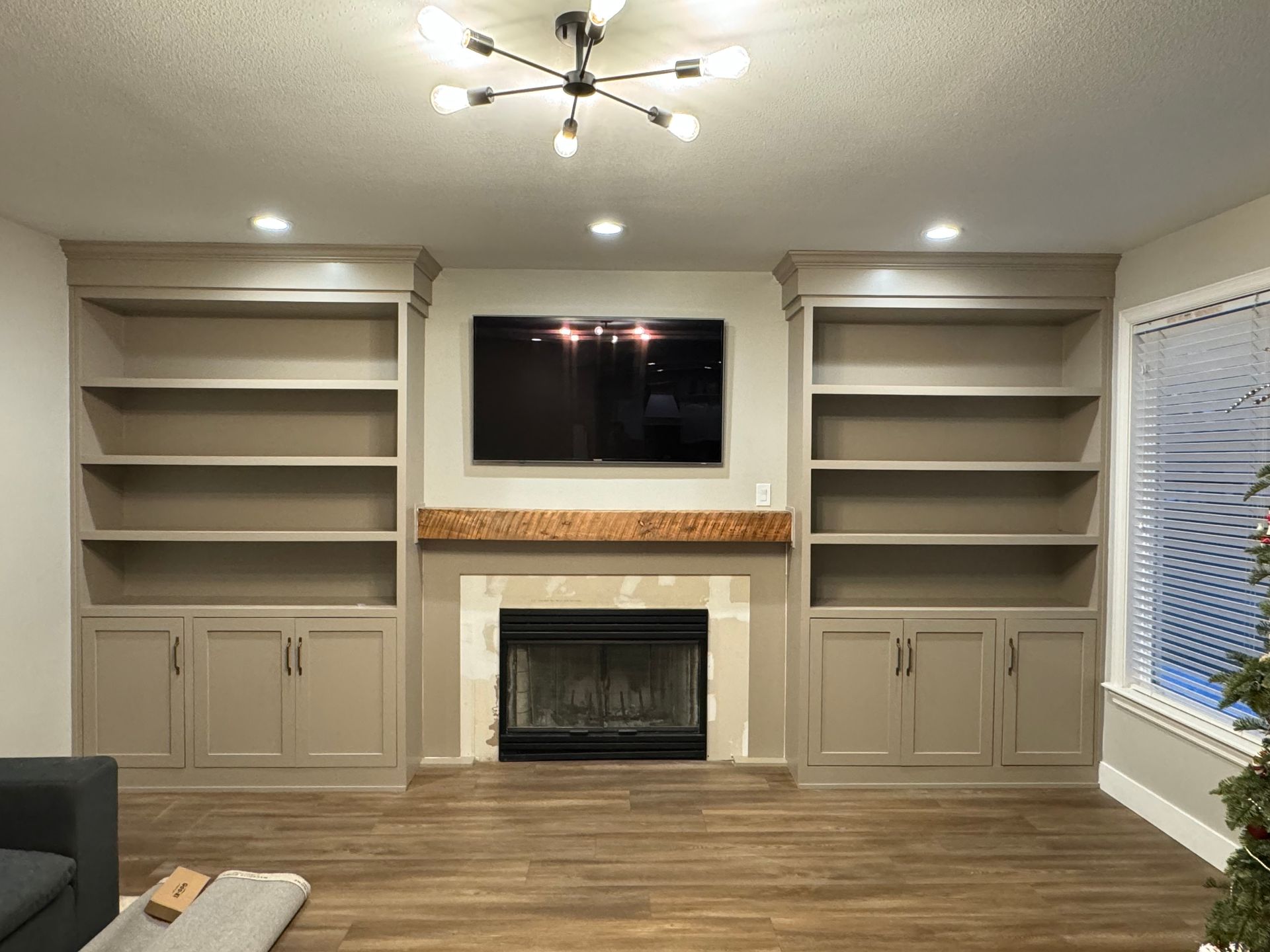 Living room with built-in bookshelves, fireplace, and a TV.  The space has a modern design with neutral colors.