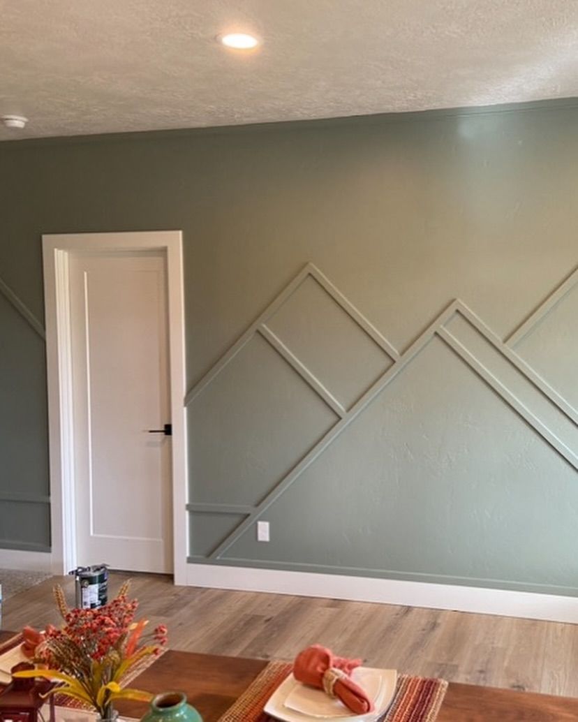 Green wall with white trim and geometric design, door.