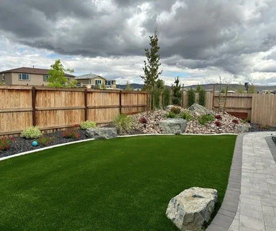 A fenced in yard with tended green grass
