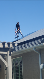 A man is standing on the roof of a house