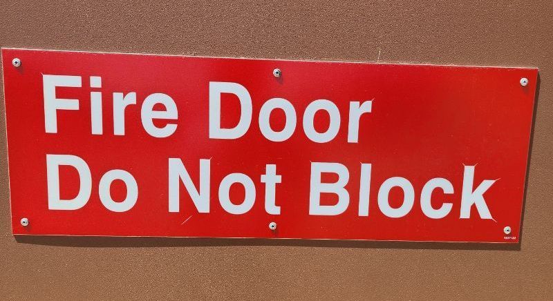 A red sign that says fire door do not block