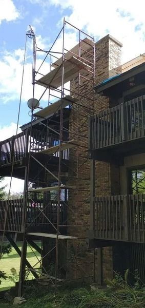 Scaffolding erected on a building to work on a chimney. Sunny day.
