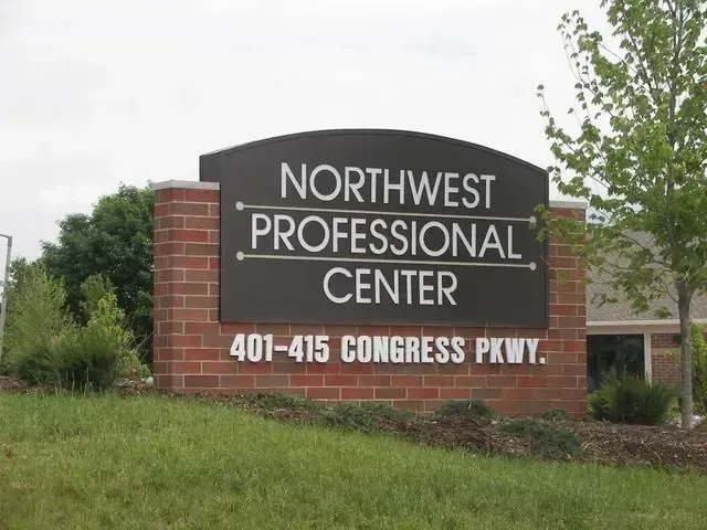 Sign for Northwest Professional Center, on a brick and black sign with white text. Address is on the bottom.