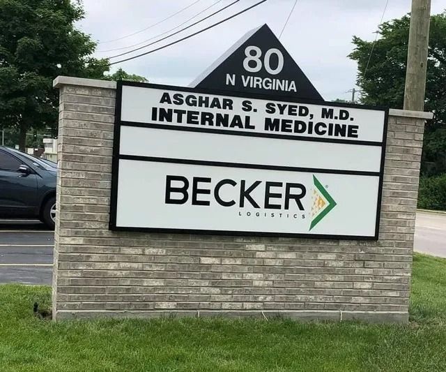 Sign for Asghar S. Syed, M.D., Internal Medicine and Becker Logistics, on a brick wall at 80 N Virginia.