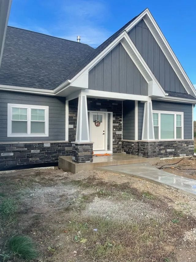 Gray house with white trim, stone accents, and a front porch.
