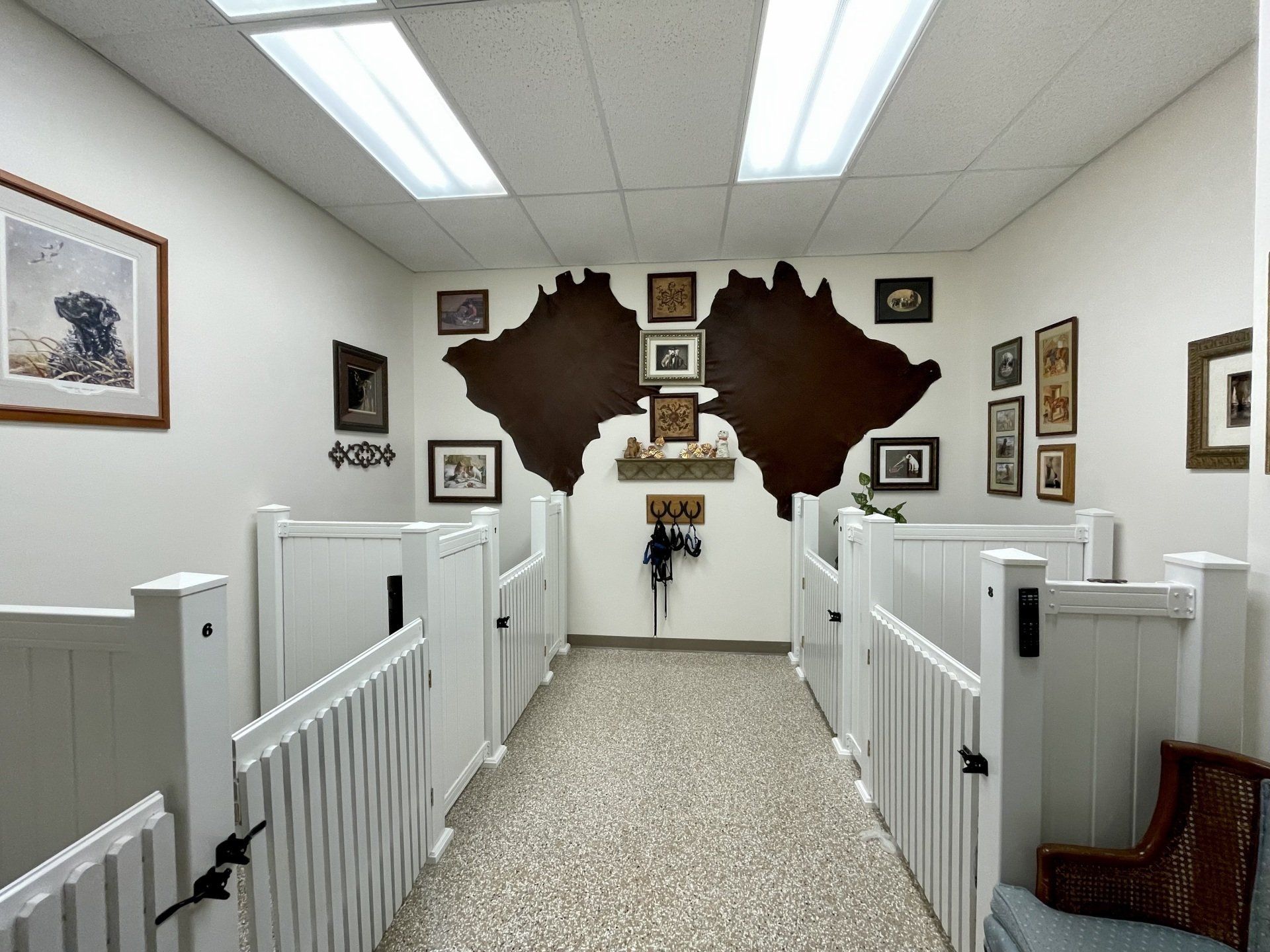 A hallway with white fences and pictures on the wall